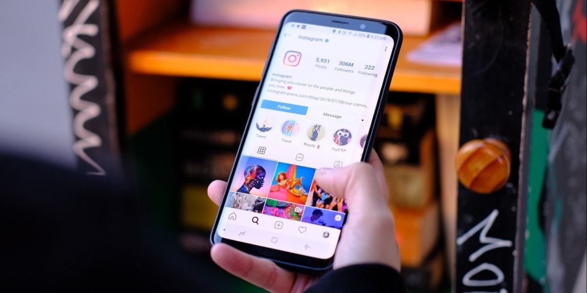 A mobile phone with social media stories on the screen